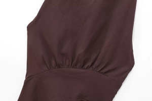Dettaglio ravvicinato della vita arricciata di un top marrone scuro con scollo all'americana