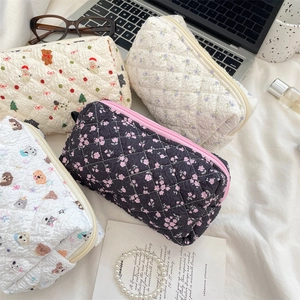 Detailed overhead view of four assorted quilted fabric pouches with floral and animal prints