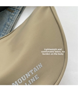 Dettaglio della borsa a mezzaluna in nylon kaki con logo Mountain Line e cuciture fini