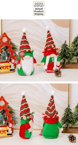 Close-up of Christmas gnomes plush set with striped hats and bells in festive decor