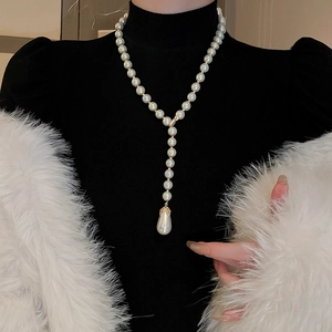 Detailed view of elegant gold Y-shape long necklace with teardrop pearl pendant