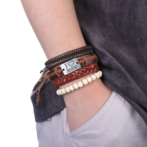 Détail macro de quatre bracelets multicouches en cuir tressé avec plaque I Love Jesus