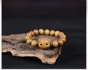 Gros plan sur le charm tête de chat sculpté sur un bracelet en bois de santal naturel
