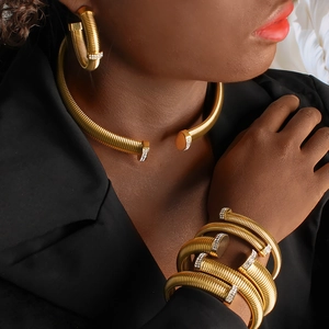 Detail shot of elegant gold spring-shaped jewelry set with sparkling zircon accents