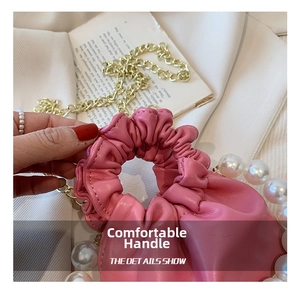 Detail of pink leather handbag with pearl handle and stylish scrunchie style handle