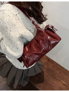 Retro burgundy shiny leather crossbody bag with multiple zippers shown on a model