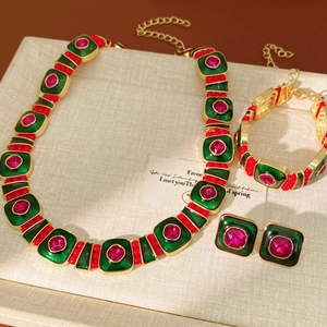Macro shot of vintage style jewelry set with green enamel and pink gemstones