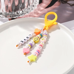Détail du porte-clés à perles jaunes avec lettres LOVE, visage souriant et pendentif cœur