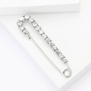 Detail view of silver alloy safety pin brooch with sparkling rhinestones for coats