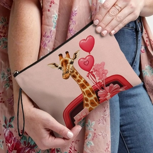 Pink canvas cosmetic bag with giraffe heart illustration held by a model