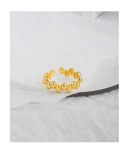 Close-up of golden S925 sterling silver beaded ring detail on elegant mirror base