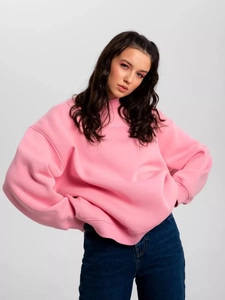 Pink oversized sweatshirt with white maskin embroidery paired with denim jeans