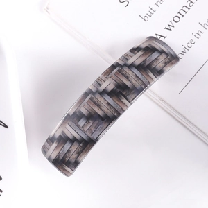 Macro view of checkered rectangle hair clip with taupe woven texture and spring mechanism