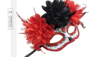 Detail of Day of the Dead mask with red glitter, faux flowers and black feathers