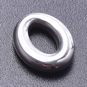 Macro shot of oval 18k gold plated stainless steel bead on a textured black surface