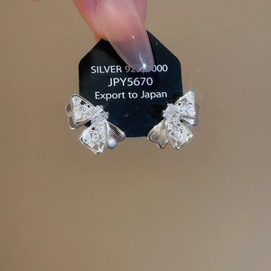 Macro shot of silver 925 bowknot stud earrings with sparkling pavé cubic zirconia