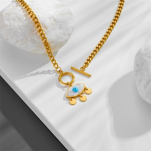 Gold evil eye necklace with natural shell pendant and Cuban chain on white stones