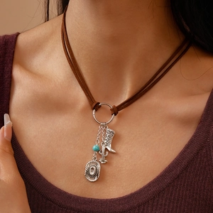 Detail of western style necklace featuring cowboy boot and cactus charms on suede cord
