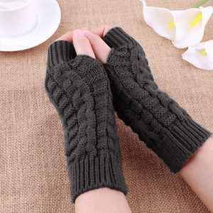 Close-up of dark grey cable knit fingerless gloves showing thick wool texture and wrist detail