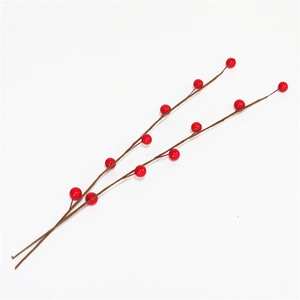 Detailed close-up of artificial red berries on brown stems for DIY Christmas decor