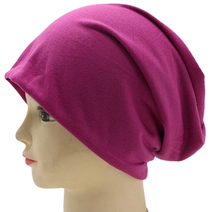 Detail of rose purple knitted slouchy beanie on model head with clear fabric texture