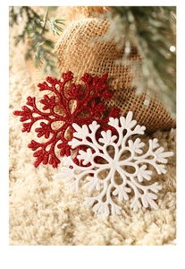 Detail of red and white glitter snowflake ornaments on a plush rug by a tree base