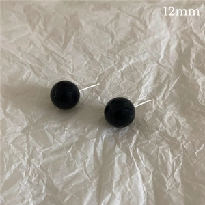 Detailed close-up of 12mm black onyx stud earrings on minimalist white background