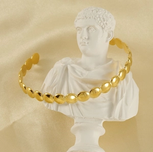 Detail of 18K gold-plated stainless steel bead cuff bracelet on a white bust statue