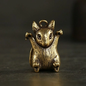 Vue macro d'un pendentif rat du zodiaque en laiton avec détail de l'anneau de suspension