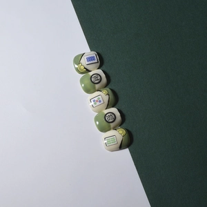 Macro detail of 3D embossed mahjong nail art stickers with glossy resin texture and gold accents