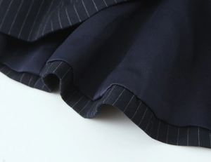 Close-up of navy blue pinstripe fabric with smooth lining and fine stitching texture