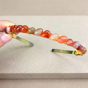 Detail of handmade gold metal headband featuring raw red crystal stones and wire wrapping