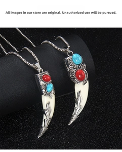 Detailed view of tribal wolf tooth necklace with red and turquoise gems on black leather