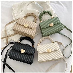 Close-up of quilted mini handbags with heart clasps and ruched cloud-style top handles