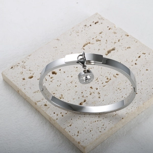 Close-up of silver-plated bracelet with a sparkling crystal-set round pendant charm
