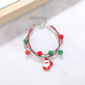 Detail of Christmas bracelet with Santa charm, beads and bells on woven red green cord