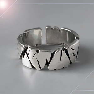 Detalle macro de anillo de plata con textura de piedra vintage y diseño geométrico