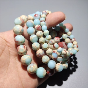 Detailed macro view of smooth light blue and reddish brown patterned round bead bracelets