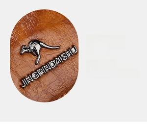 Detailed close-up of brown lychee grain leather texture with metallic kangaroo emblem