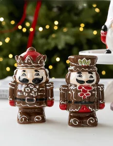 Detail of ceramic nutcracker salt and pepper shakers with festive Christmas tree background