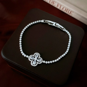 Macro shot of silver zircon clover bracelet with tennis chain on a leather jewelry box