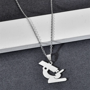 Detailed close-up of a silver microscope-shaped pendant on a polished stainless steel chain