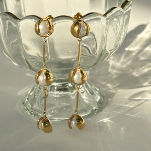 Close-up of 18k gold vintage drop earrings with elegant pearls on glass