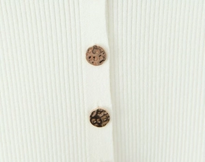 Gros plan détaillé du tricot blanc à rayures verticales et boutons décoratifs en léopard