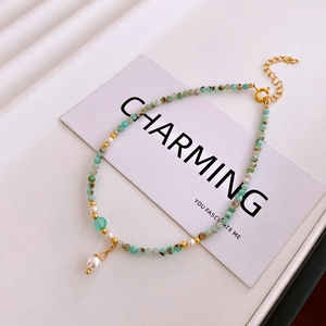 Detail of amazonite beaded anklet with pearls and gold spacers on elegant white card