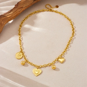 Detail of vintage gold plated stainless steel necklace with rose and love heart pendants