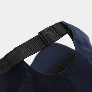 Detail of adjustable buckle strap and breathable fabric on navy blue sports baseball cap