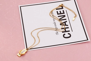 Detailed view of gold double-ring necklace with Roman numerals and inlaid crystal pendant