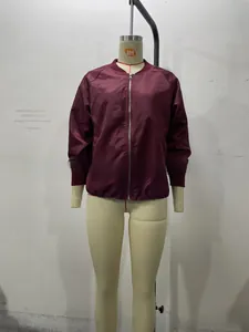 Detail of burgundy bomber jacket showing ribbed collar, cuffs and front zipper closure