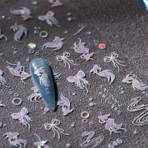 Macro shot of gold foil fish tail and butterfly nail stickers with laser textures